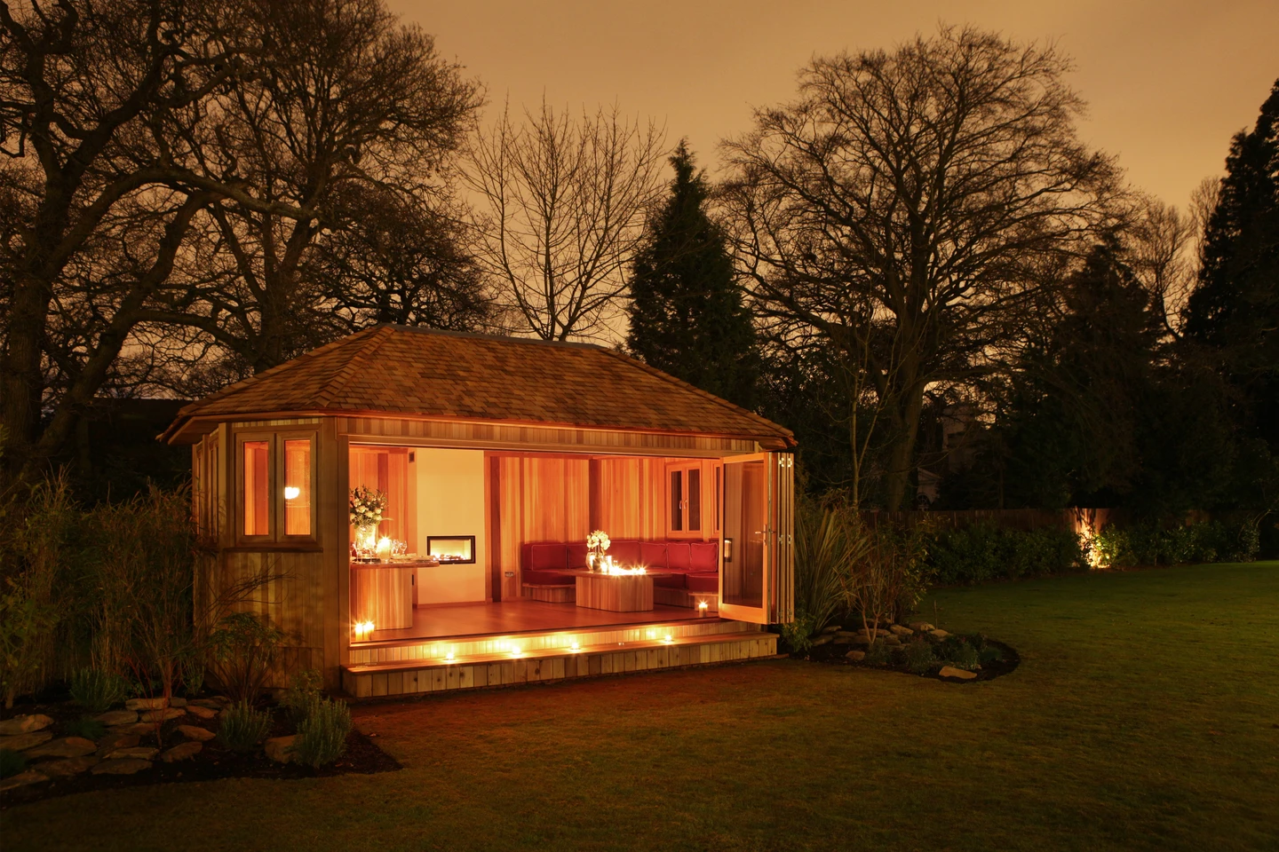 Crown Pavilions garden room at twilight with warm interior lighting